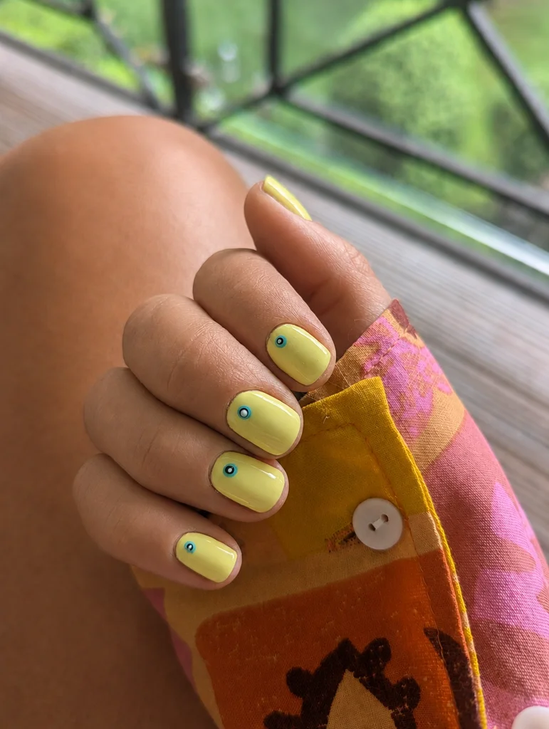 Trendy summer yellow BIAB nails with evil eye nail art in Dublin